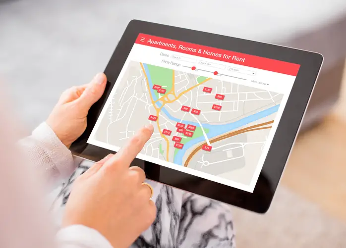 person-using-tablet-displaying-map-with-apartments-rooms-and-homes-for-rent