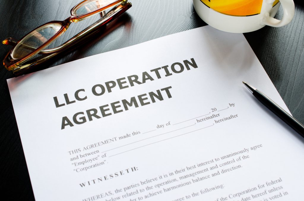 llc-operation-agreement-paperwork-on-desk-with-glasses-mug-and-pen